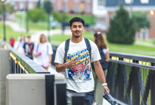 Young man walking on viaduct